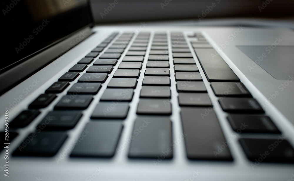 Photo side view of a modern laptop keyboard. Business, internet technology, social network concept. Typing on laptop computer keyboard, connecting internet in office. . High quality photo