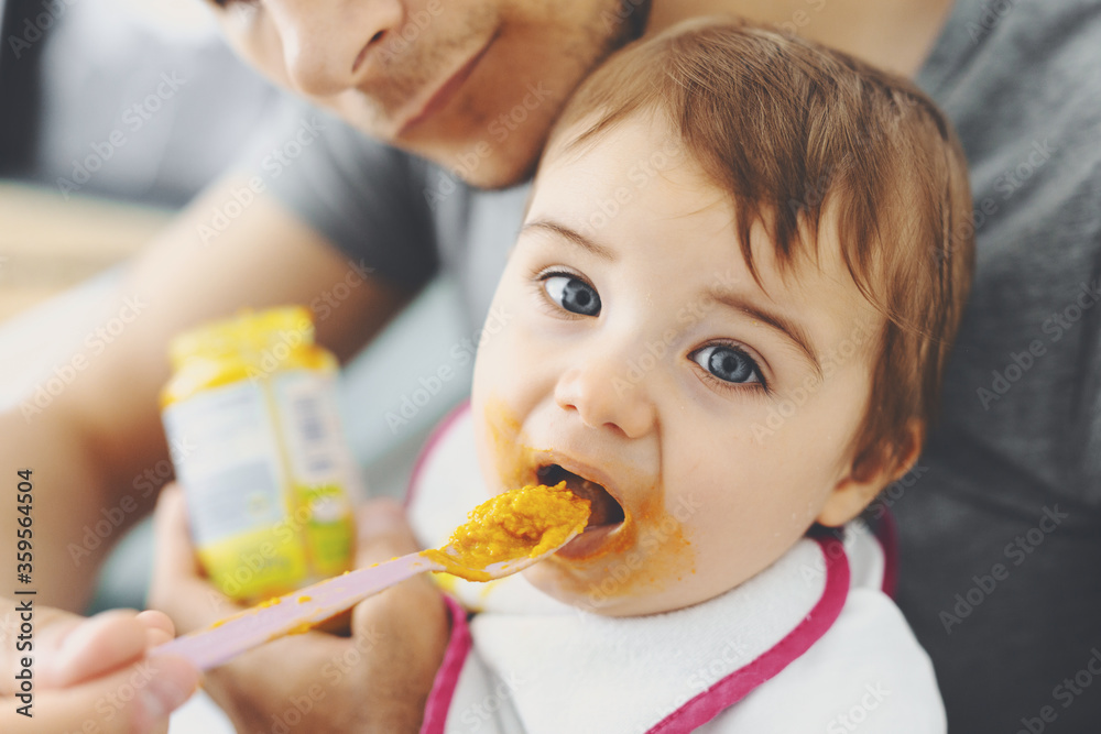 Dad feeding baby boy with spoon Dad feeding baby boy with spoon