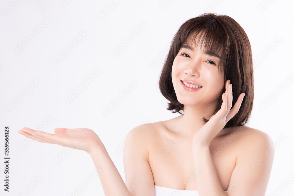 Beautiful young Asian women smile and pointing to copy space for display Cosmetics product feeling happiness with Healthy Clean and Fresh Skin,Isolated on white background, Beauty Concept. Beautiful young Asian women smile and pointing to copy space for display Cosmetics product feeling happiness with Healthy Clean and Fresh Skin,Isolated on white background, Beauty Concept.