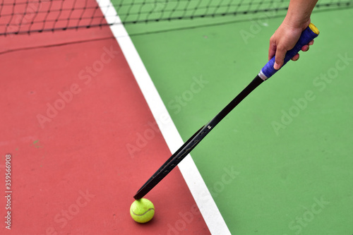 Catching Ball while holding tennis racket in hand.