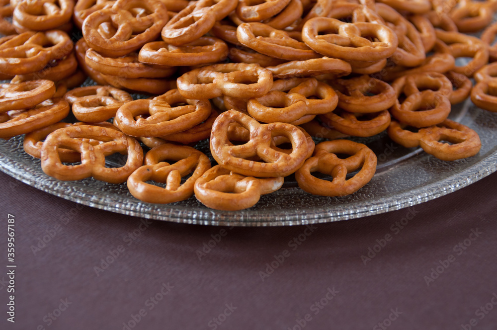 Pretzel cookies in a transparent plate on a brown background Pretzel cookies in a transparent plate on a brown background