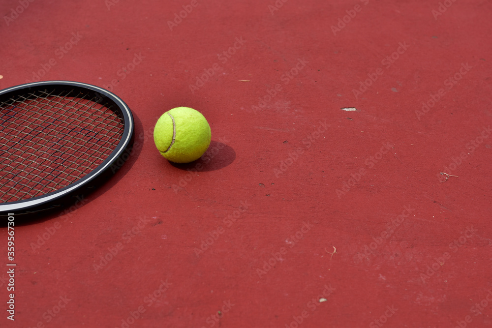 Closeup of Tennis Racket and balls on Tennis Courts in the outdoors.