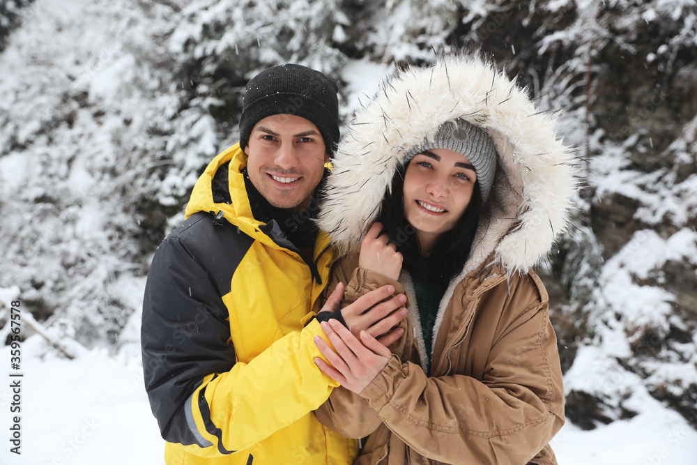 Lovely couple outdoors on snowy day. Winter vacation