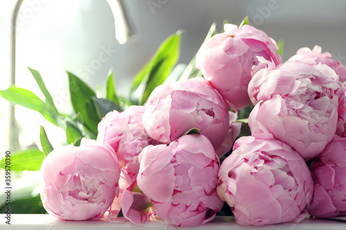 Fototapeta Naklejka Na Ścianę i Meble -  Bouquet of beautiful pink peonies on counter in kitchen