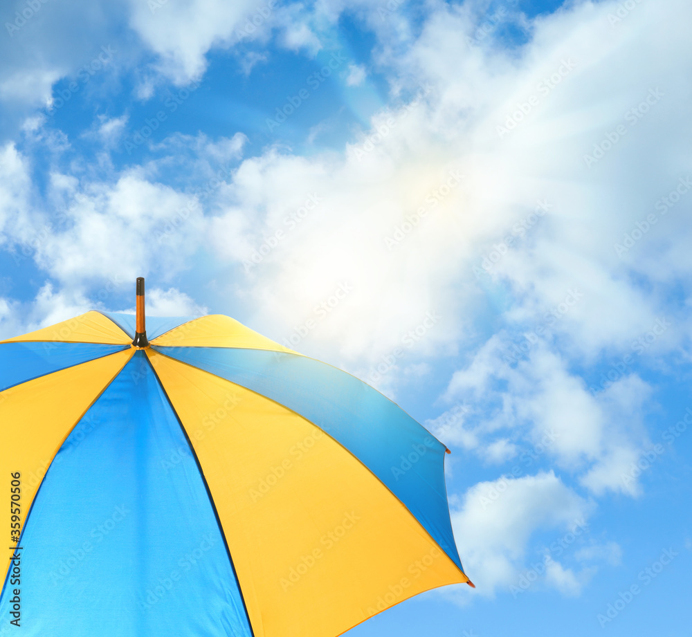 Modern bright umbrella against blue sky. Sun protection