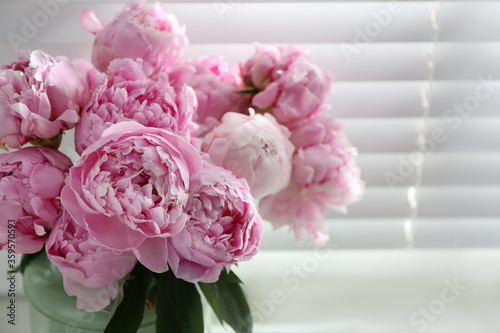 Bouquet of beautiful peonies near window  closeup