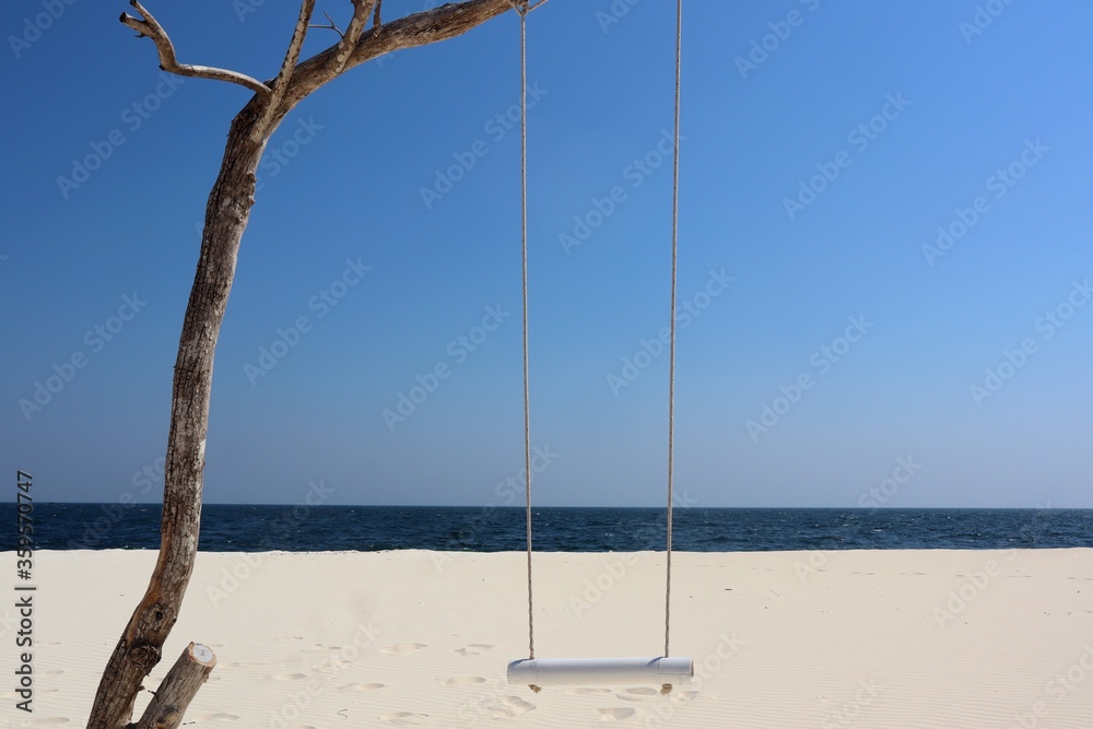 Beautiful beach. Tranquil scenery, relaxing beach, tropical landscape design. Sali Island, Myanmar. Maldives Of Myanmar. Beach with wooden swings. Twigs with a white rope swing on the beach. holiday. 