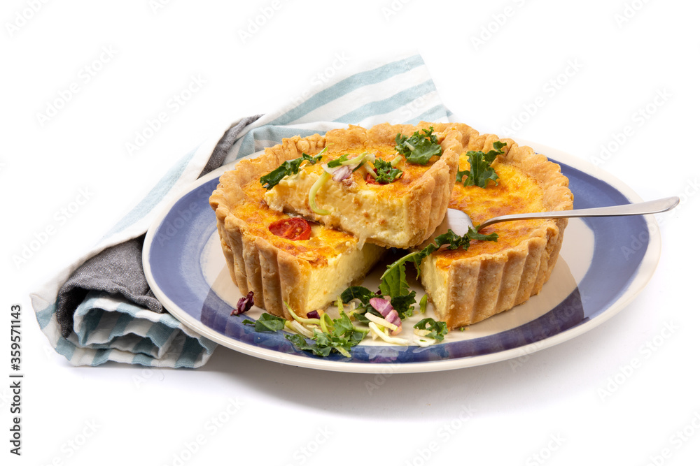 a cheese quiche with dried tomatoes with one piece cut out ready to serve isolated on white

