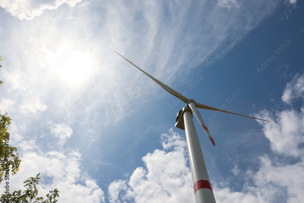 Modern wind turbine against cloudy sky, low angle view. Alternative energy source