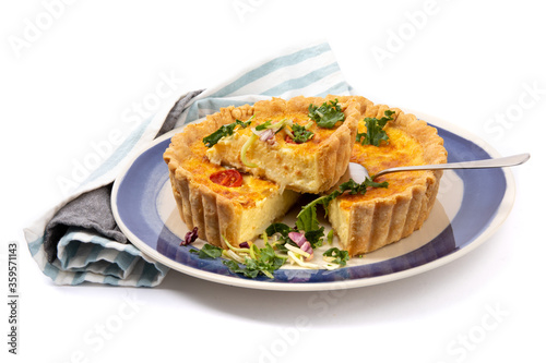 a cheese quiche with dried tomatoes with one piece cut out ready to serve isolated on white