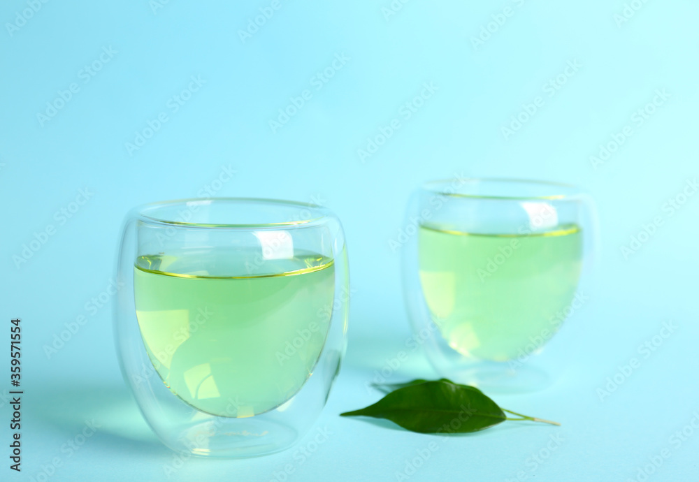 Aromatic green tea and leaves on light blue background Aromatic green tea and leaves on light blue background