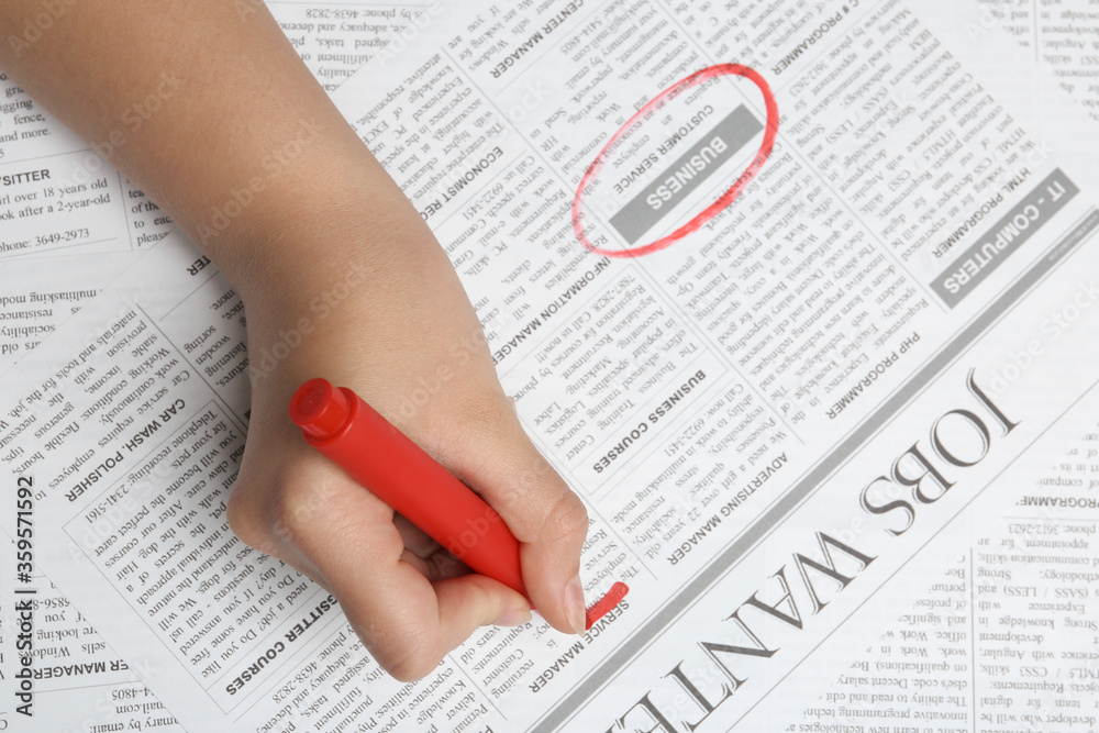 Woman marking advertisement in newspaper, closeup. Job search concept Woman marking advertisement in newspaper, closeup. Job search concept