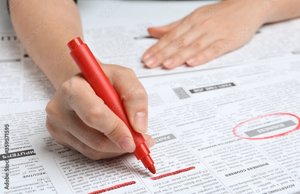 Woman marking advertisement in newspaper, closeup. Job search concept Woman marking advertisement in newspaper, closeup. Job search concept