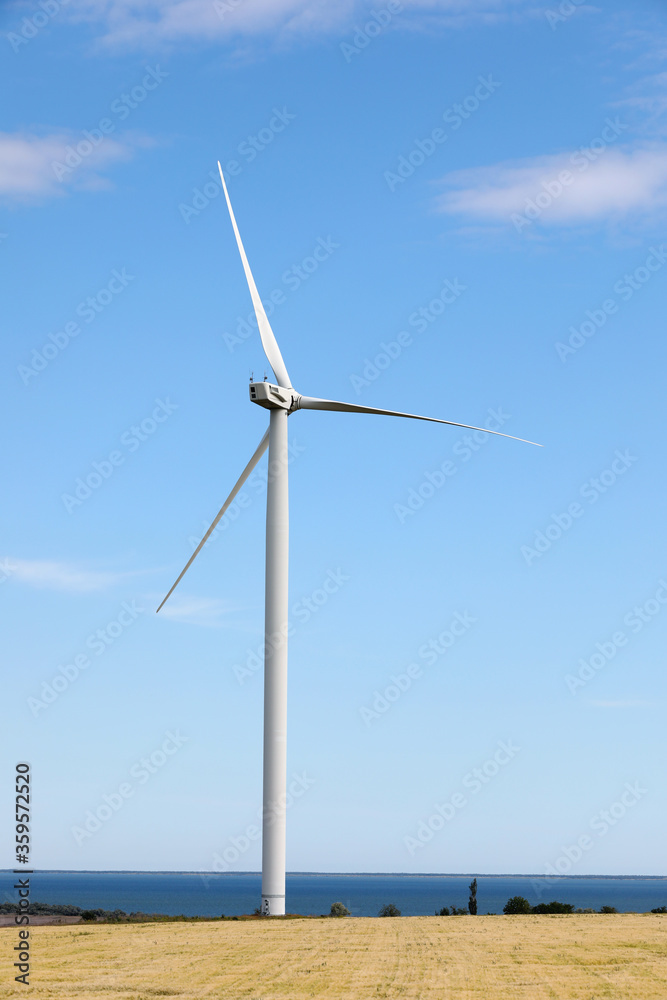 Fototapeta premium Beautiful view of field with wind turbine. Alternative energy source