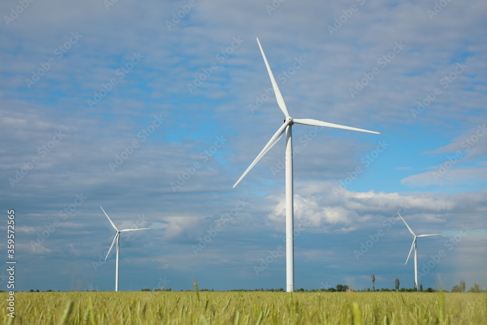 Beautiful view of field with wind turbines. Alternative energy source Beautiful view of field with wind turbines. Alternative energy source