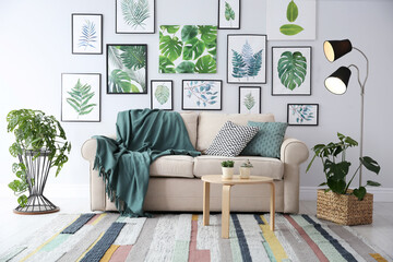 Beautiful artworks and comfortable couch in stylish room. Interior design