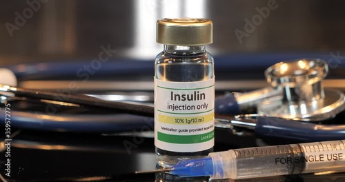 Vial of insulin injection with syringe and stethoscope photo