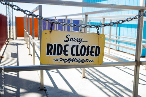 ride closed sign hanging on empty amusement park ride