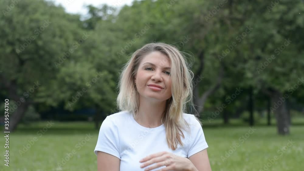 portrait of a beautiful thirty five year old caucasian woman in summer park and white t-shirt hd stock footage portrait of a beautiful thirty five year old caucasian woman in summer park and white t-shirt hd stock footage