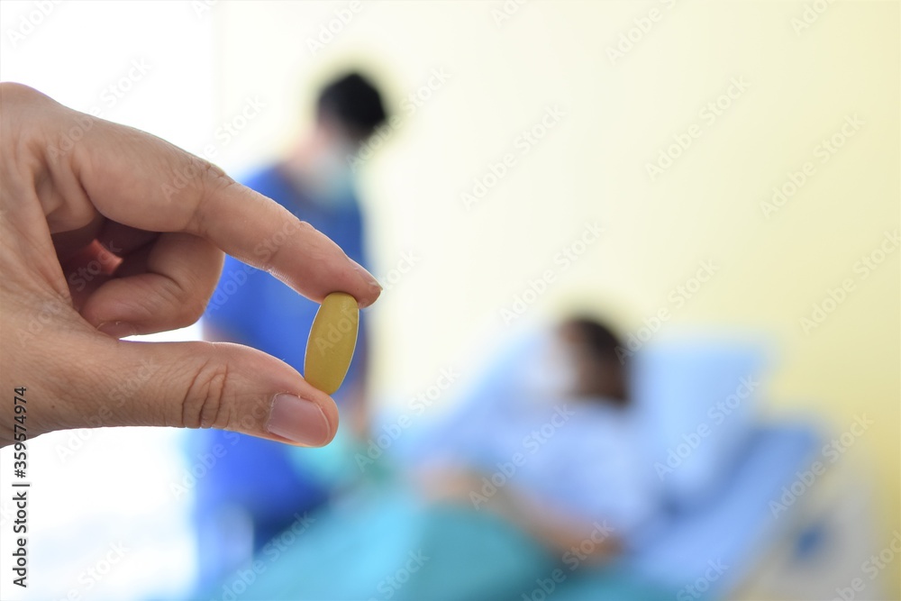 woman holding pills in hand on blur room background