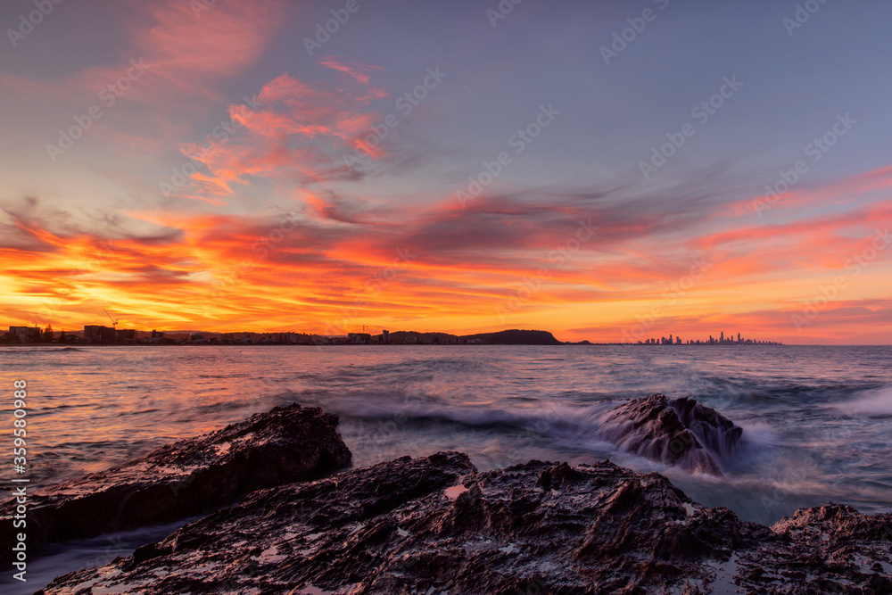 Colourful sunset views and ocean tide over the rocks at Currumbin Rock Gold Coast