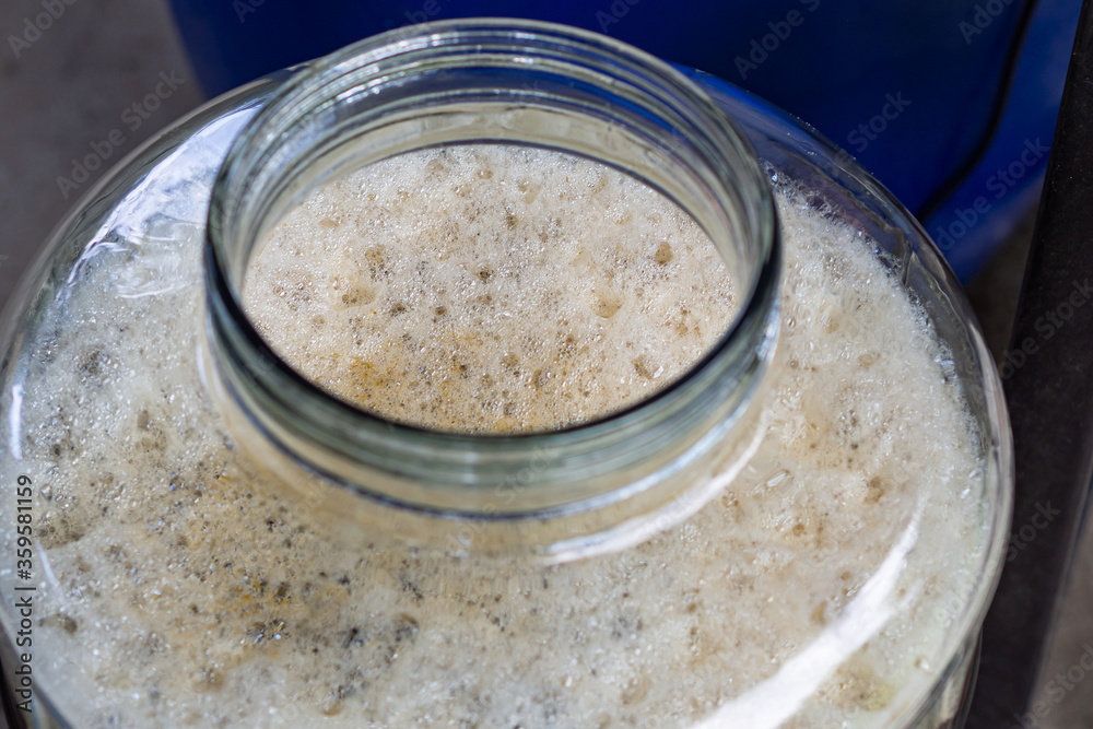 Close-up of craft beer and foam in fermentation container. Close-up of craft beer and foam in fermentation container.