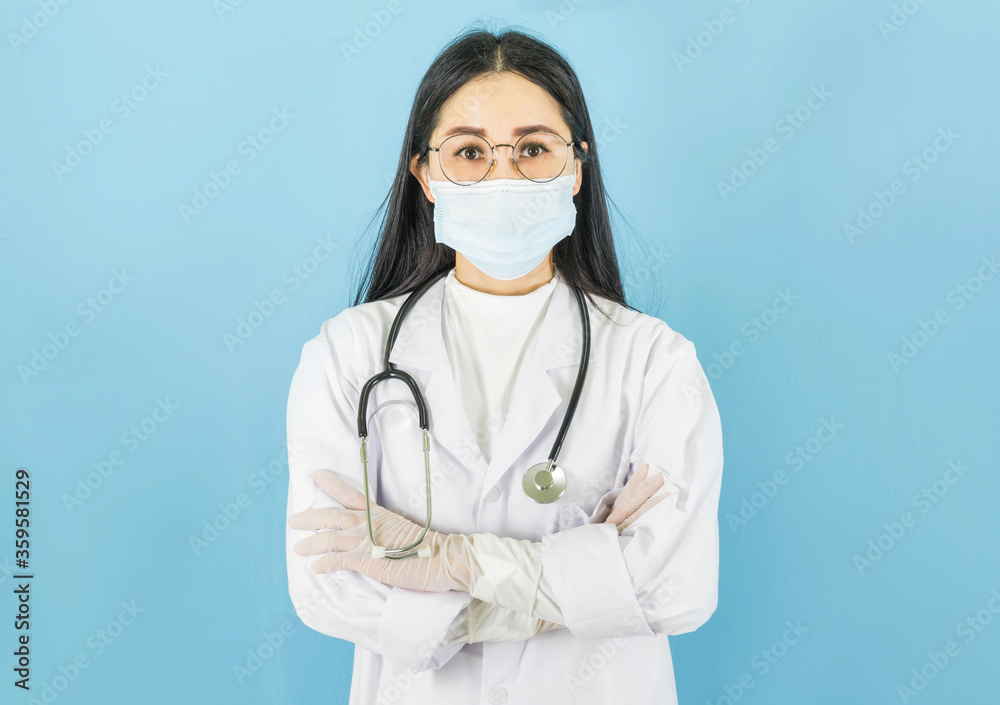 Smart young asian female doctor in lab coat with Medical face mask,white latex medical gloves and stethoscope against blue background,health care concept Smart young asian female doctor in lab coat with Medical face mask,white latex medical gloves and stethoscope against blue background,health care concept