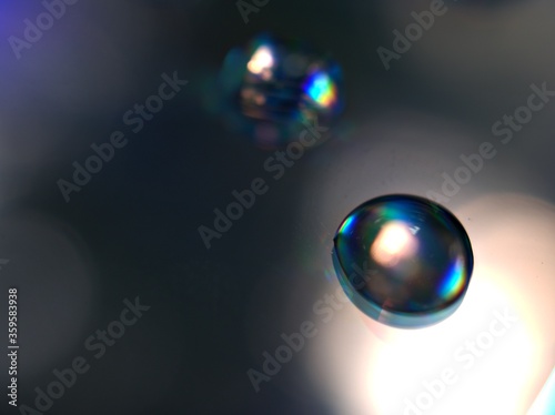 blurred water droplets with blue light on black backgronud  dark and shiny   abstract background  macro image for card design