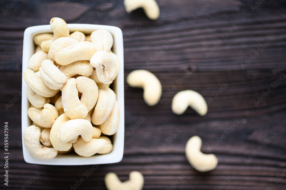Full Raw Cashew Nuts in white ceramic bowl Full Raw Cashew Nuts in white ceramic bowl
