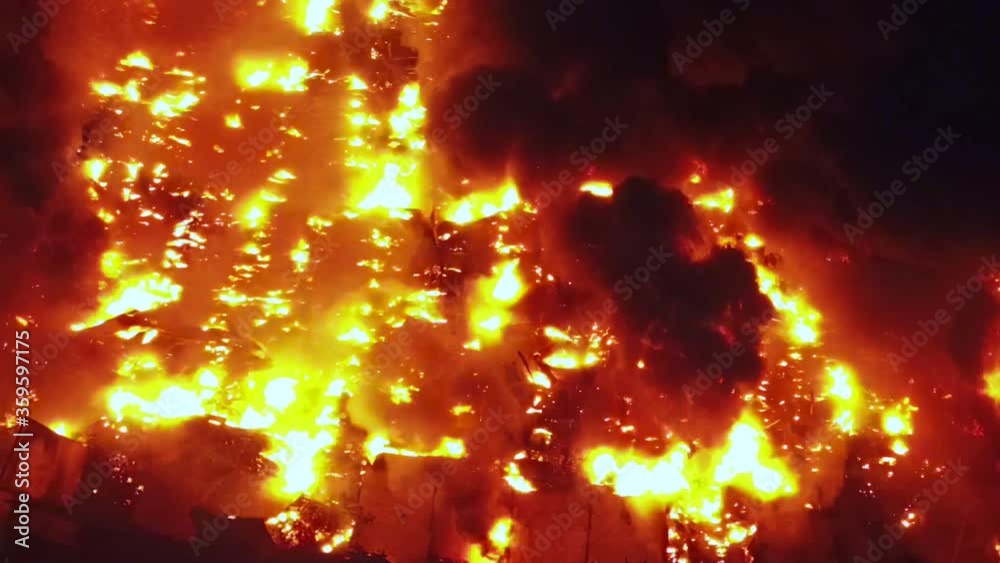 Aerial, top down, drone shot over the Australian bushfires, glowing, red forest, causing global warming and climate change, trees burning on a summer night, in Queensland, Australia