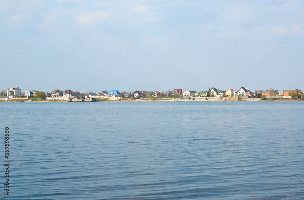 expanse of river water with houses on the shore.