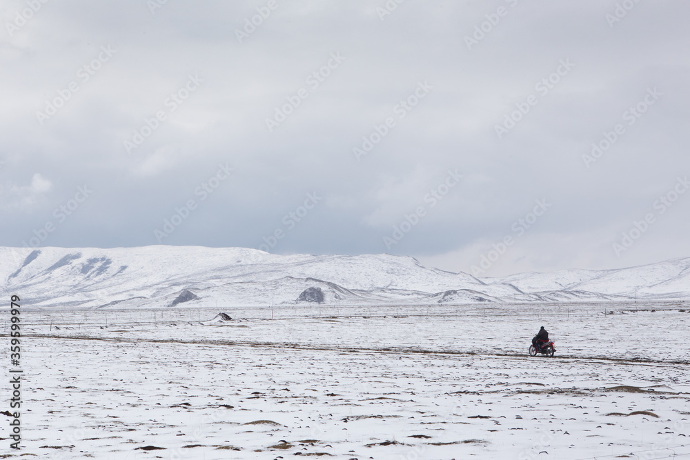 A man riding a motorcycle in snow field