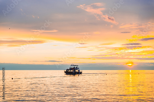 people on boat enjoying the view of sunset © phpetrunina14