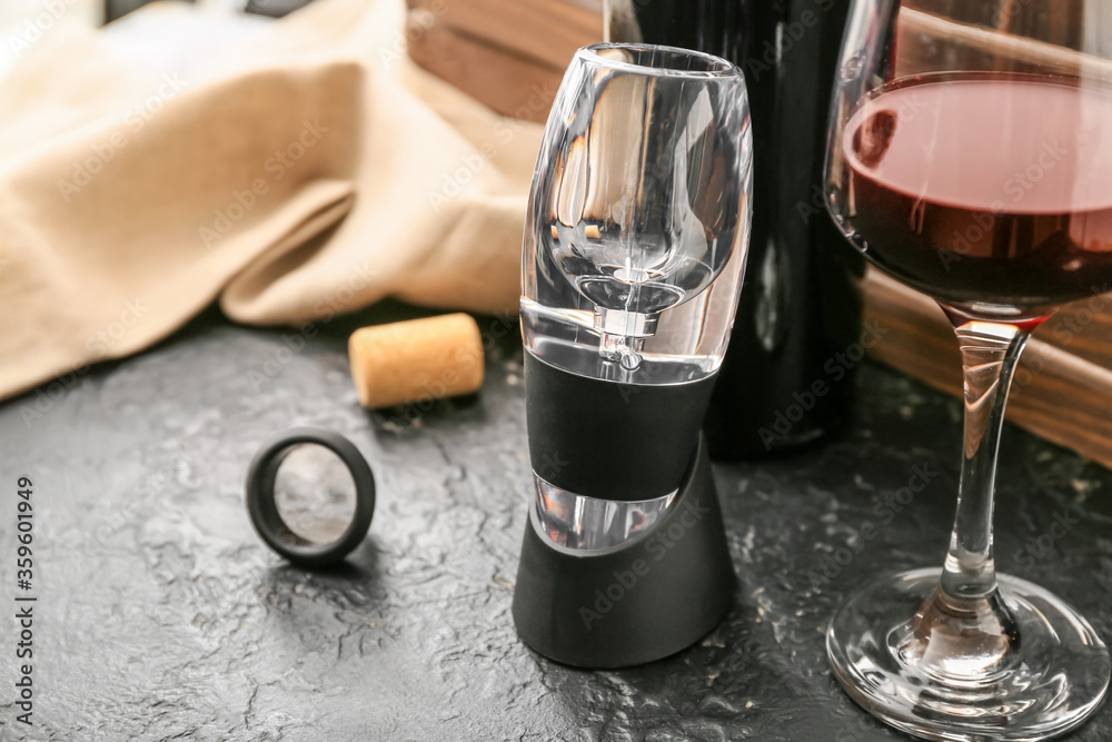 Aerator and glass of wine on dark background Aerator and glass of wine on dark background
