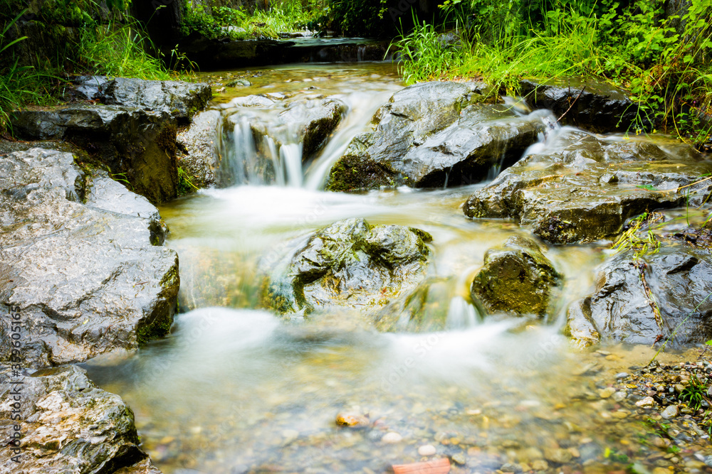 Kleiner faszinierender Wasserfall mit Steinen Kleiner faszinierender Wasserfall mit Steinen