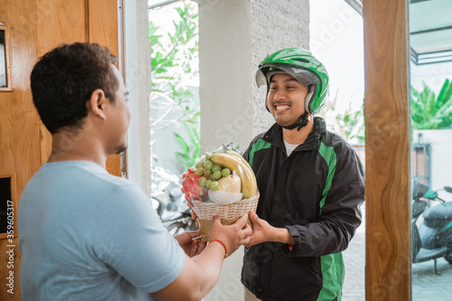 portrait of asian delivery man delivering fruit parcel