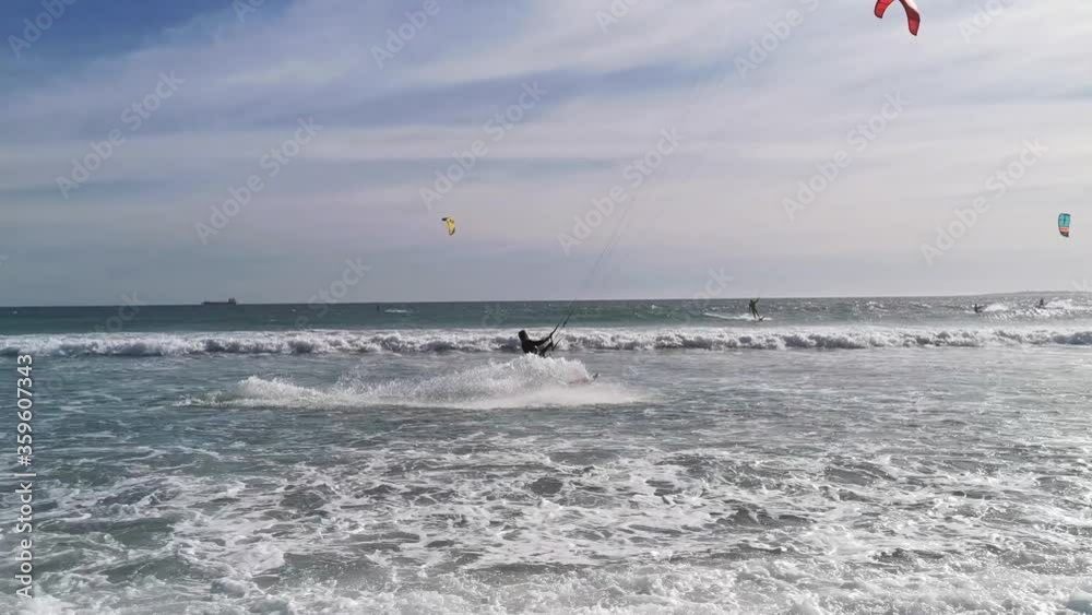 A professional kitesurfer performs aerobatics close to the beach A professional kitesurfer performs aerobatics close to the beach
