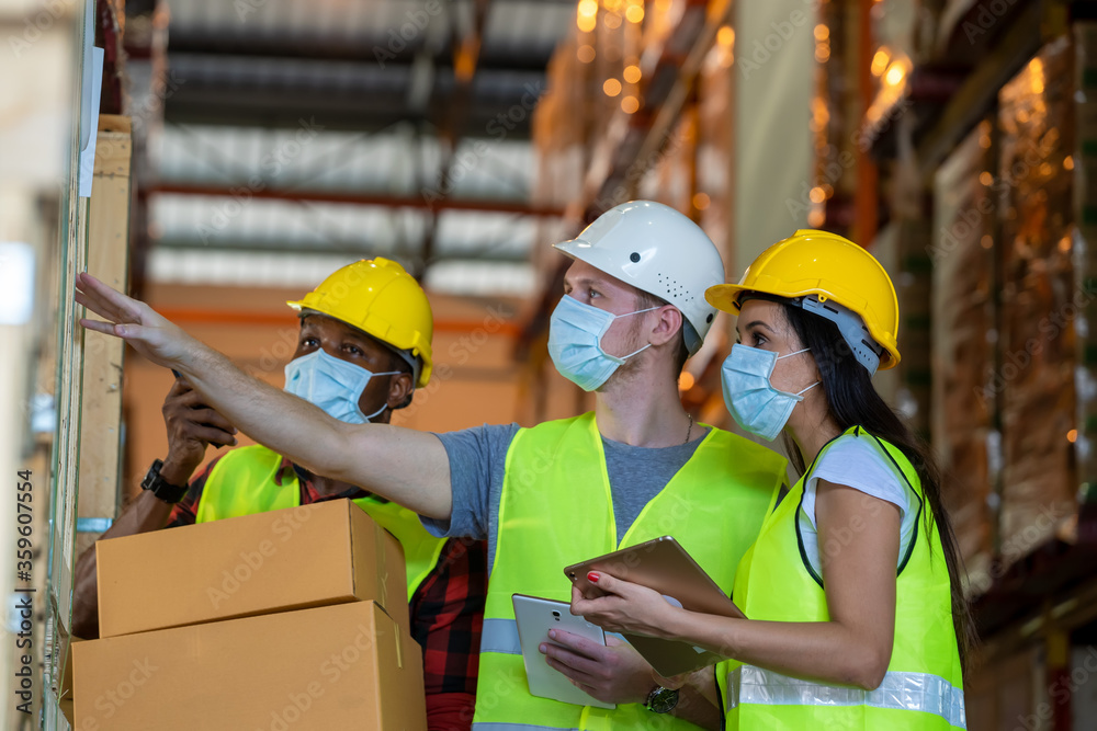 Group warehouse workers wearing protective mask to Protect Against Covid-19 working together at warehouse,Coronavirus has turned into a global emergency.