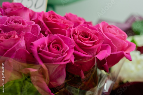 Pink roses in the window of a flower shop. Flowers in the refrigerator. Small business. Selective focus.