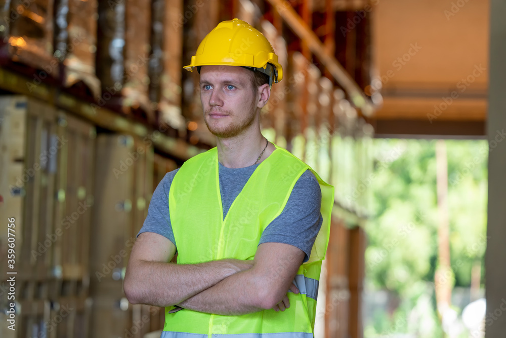 Portrait of warehouse worker standing with arms crossed in factory. Portrait of warehouse worker standing with arms crossed in factory.