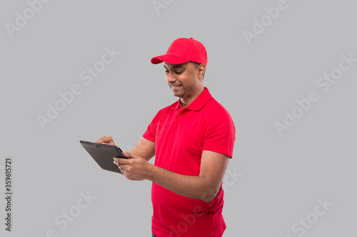 Delivery Man Using Tablet. Indian Delivery Boy with Tablet. Home Delivery Technology