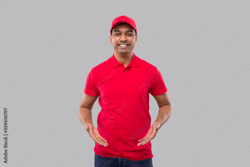 Delivery man Holding Empty Open Hands in front of Chest Isolated. Indian Delivery boy Advertisment Concept Delivery man Holding Empty Open Hands in front of Chest Isolated. Indian Delivery boy Advertisment Concept
