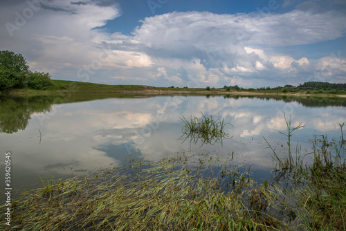 Thunderclouds over the lake. Reflection of the sky in the water.