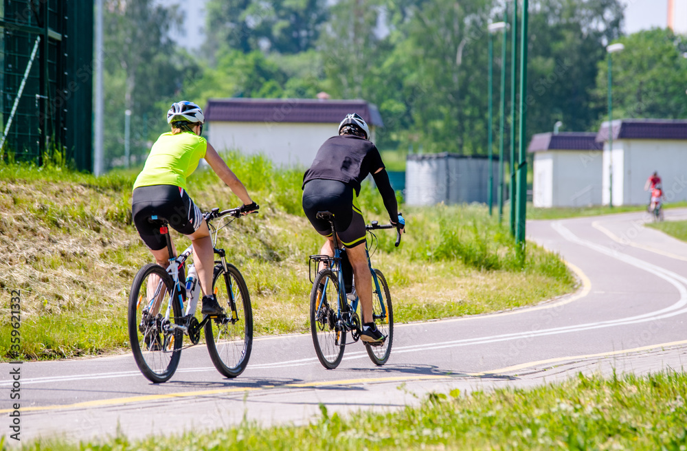 Fototapeta premium Cyclists ride on the bike path in the city Park