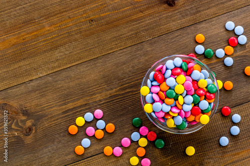 Colorful sweets on white wooden table top-down space for text