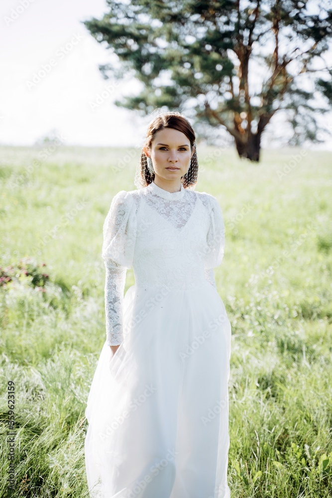 cheerful woman in long white dress standing in the field, portrait cheerful woman in long white dress standing in the field, portrait