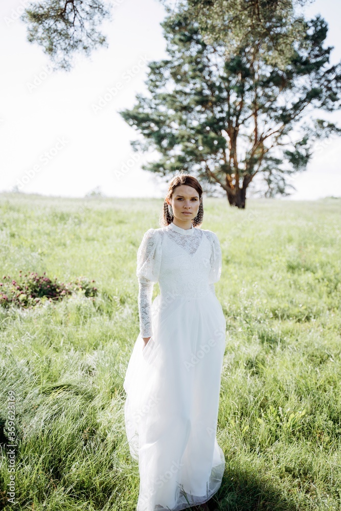 cheerful woman in long white dress standing in the field, portrait cheerful woman in long white dress standing in the field, portrait