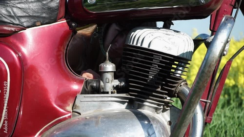 The girl repairs the motorcycle, adjusts the carburetor, the girl adjusts the retro motorcycle.Close up