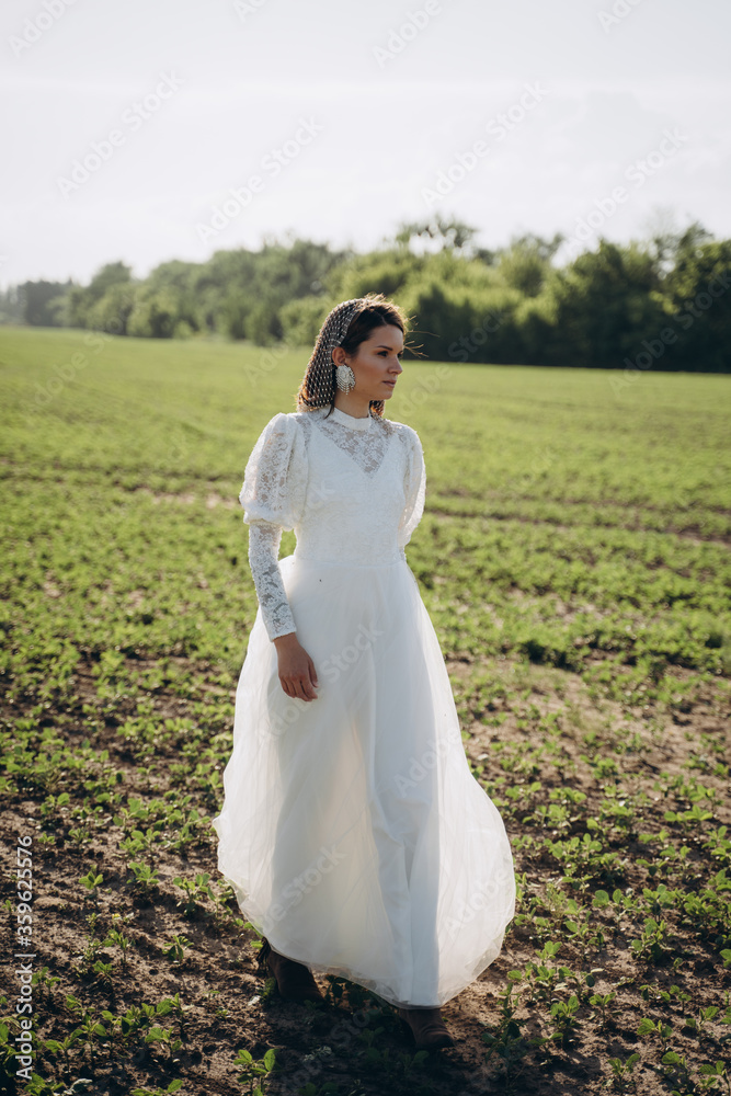 beautiful woman in long white dress posing in the field beautiful woman in long white dress posing in the field