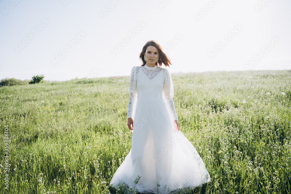bride in white dress standing in green area bride in white dress standing in green area